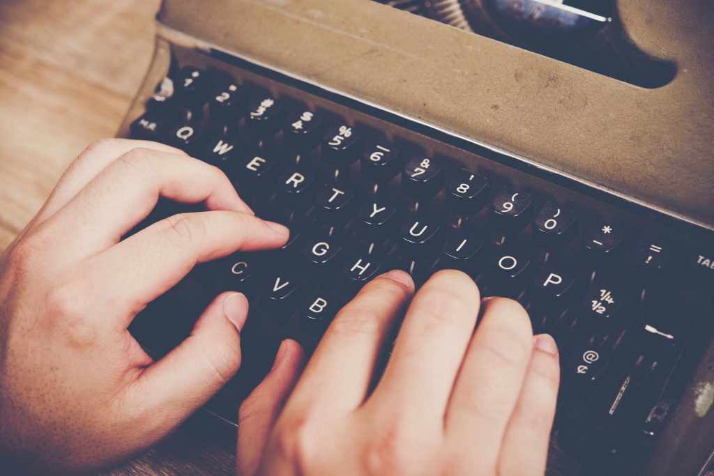 photo of hands on a typewriter for our blog post on script writing for business video