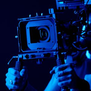 photo of a camera operator holding a camera in the dark