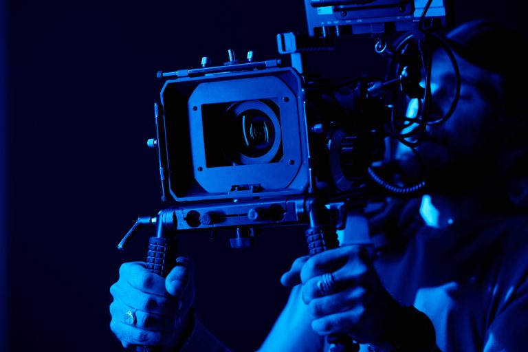 photo of a camera operator holding a camera in the dark
