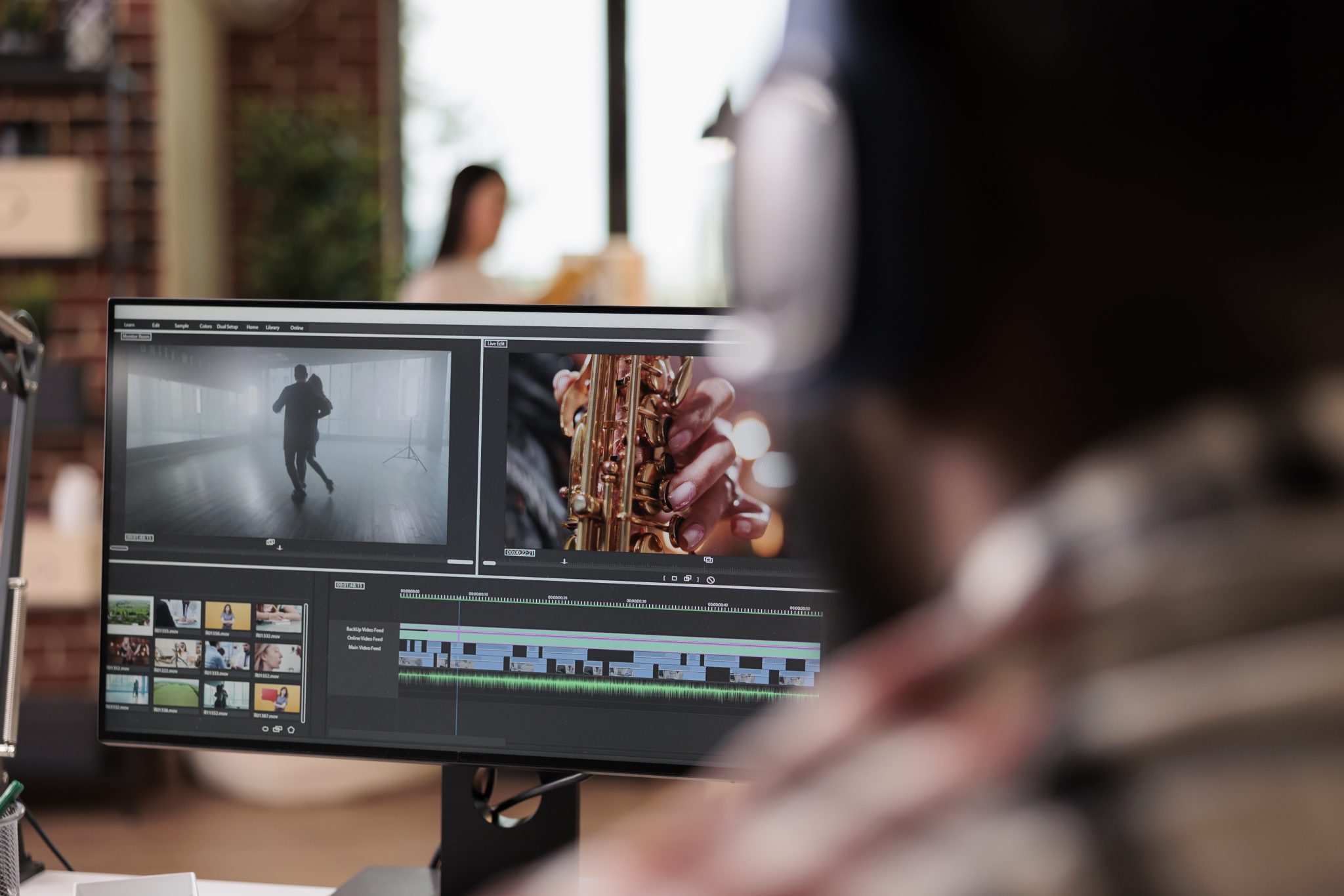 photo of a video editor behind their computer working on an edit